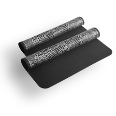 Black yoga mat with white patterns rolled up on a white background