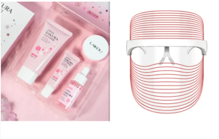 Skincare product set with pink packaging and a red and white device on a white background