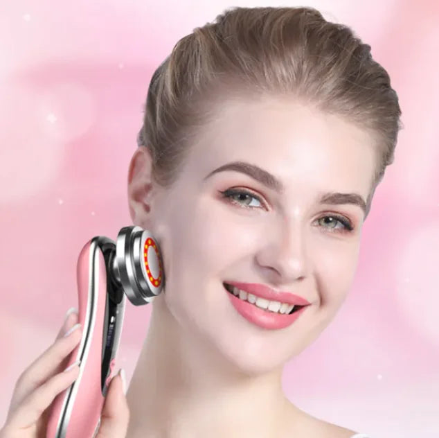Woman holding a skincare device against a pink background